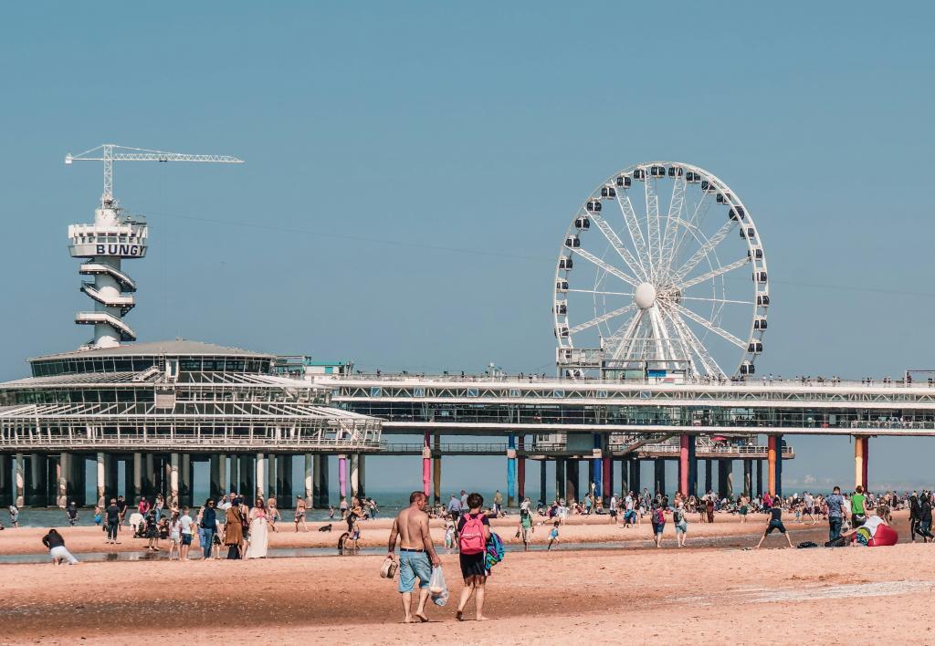 Scheveningen strand overdag in de zomer. Veel mensen wandelen over het zand.