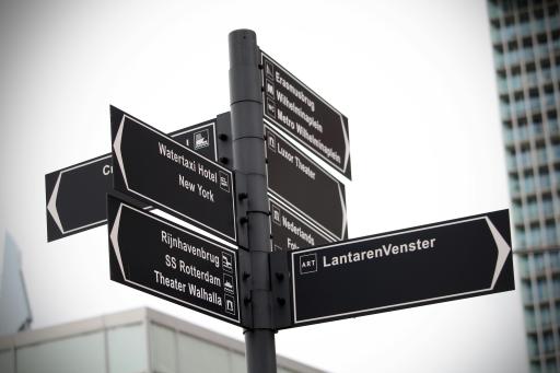 Road signs pointing to various locations in Rotterdam.