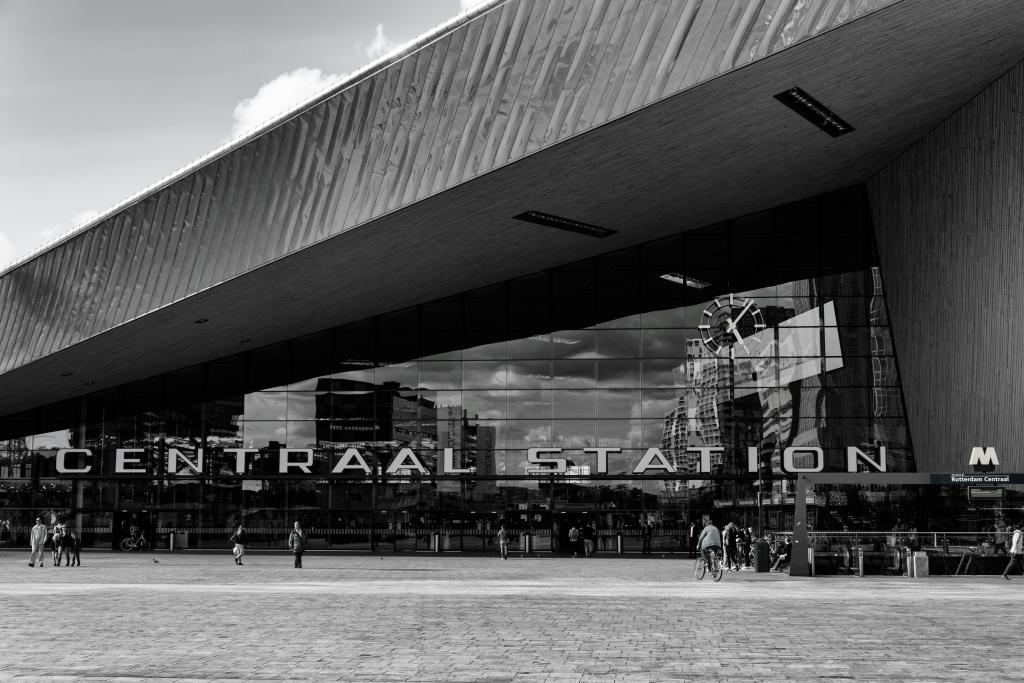 A greyscale image of Centraal Station in Rotterdam, with its distinct sloped roof and name displayed boldly out front.