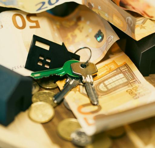 Euro notes and coins overlapping with keys resting on top.